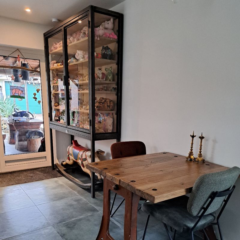 een gezellig gevulde industriele kast met glazen deuren met varkentjes een gezellig gevulde industriele kast met glazen deuren met varkentjes