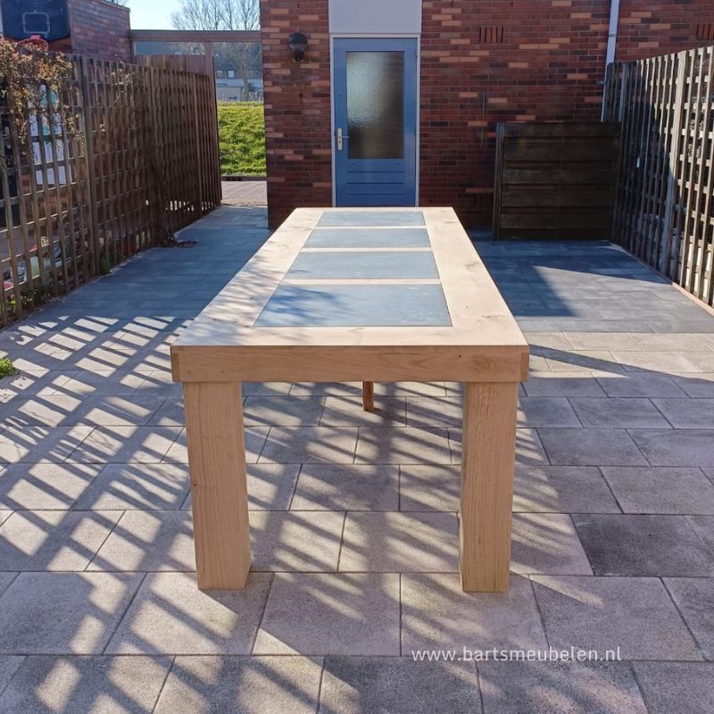 eikenhouten-tuintafel-met-natuurstenen-tegels-in-het-blad